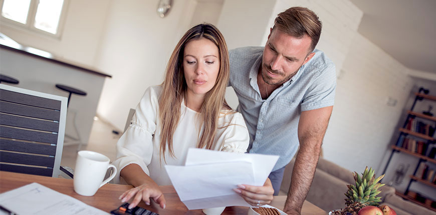 Couple going over their finances before making an application to refinance their mortgage